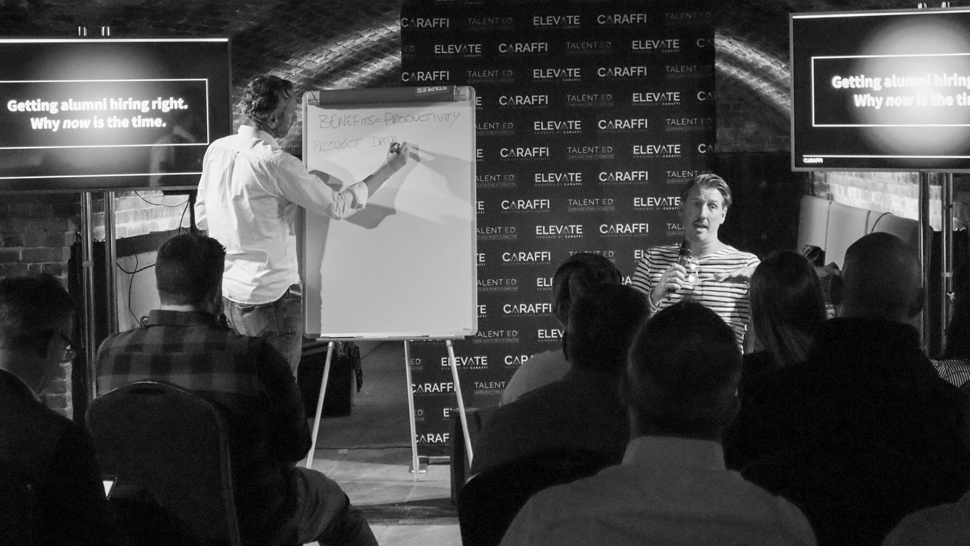 Graeme writing on whiteboard at Elevate